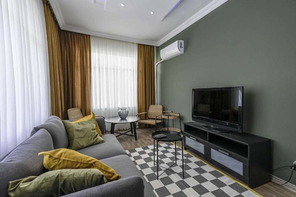 a living room with a couch and a flat screen tv at Flat with Balcony 5 min to Konyaalti Beach in Antalya