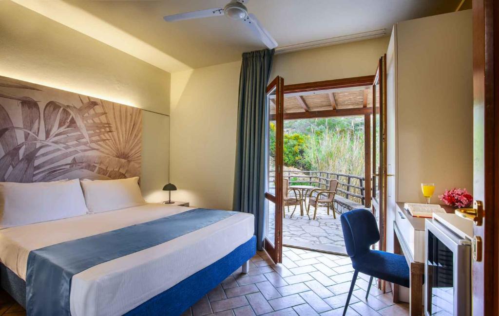 a hotel room with a bed and a balcony at Hotel Baia Imperiale in Campo nell'Elba