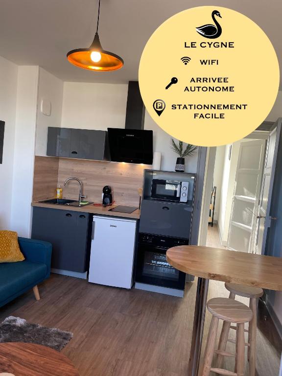 une cuisine avec une table et un comptoir dans l'établissement T2 4 pers face gare SNCF Appart Hotel le Cygne 5, à Bourges