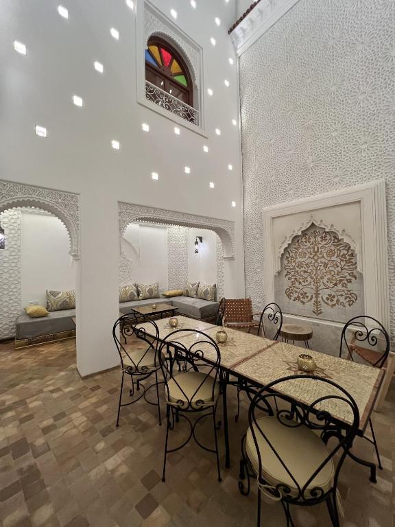 a room with a table and chairs and a couch at Riad Dar Yammi in Marrakesh