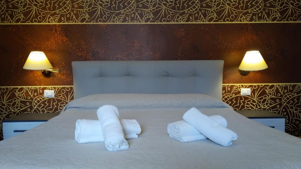 a bed with white towels on top of it at CconfortHotels R&B Central Rooms - SELF CHECK IN in Bari