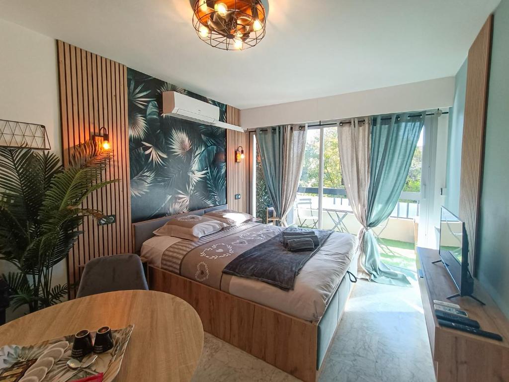 - une chambre avec un lit, une table et une fenêtre dans l'établissement Léman Holidays - Le Palm, à Mandelieu-la-Napoule