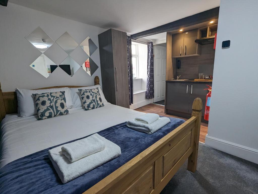 1 dormitorio con 1 cama grande y toallas. en The White Lion Hotel, Church Road, Yate BS37 5BG en Yate