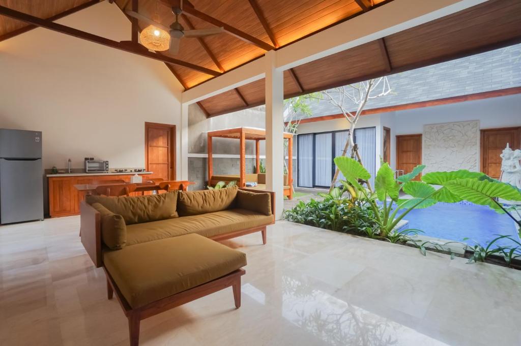 a living room with a couch and a kitchen at Villa Bulan Bali in Jimbaran