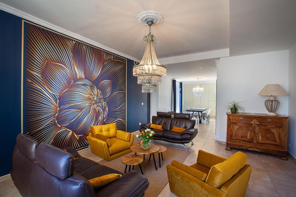 una sala de estar con sofás y una lámpara de araña. en Confidences Escale à Brissac, en Brissac-Quincé