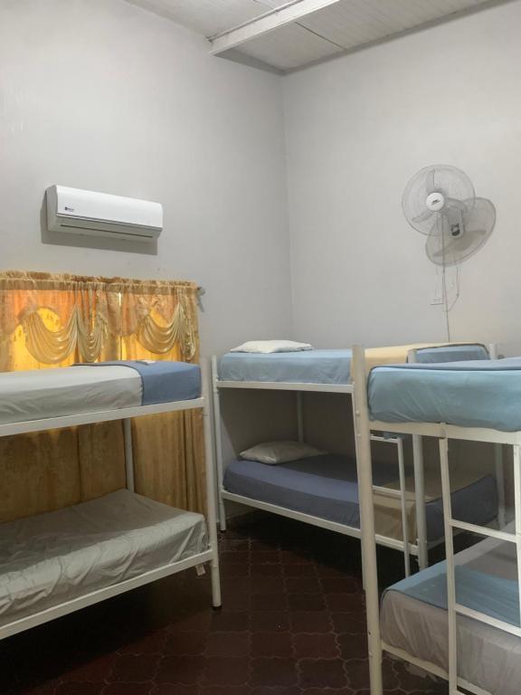a room with three bunk beds and a fan at Stella Hostel Copán in Copan Ruinas