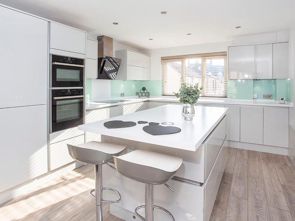 a kitchen with a white island with two stools at Holgate Lodge in York