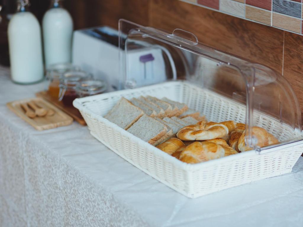 a basket of bread and pastries on a table at Rendezvous Classic House in Chiang Mai