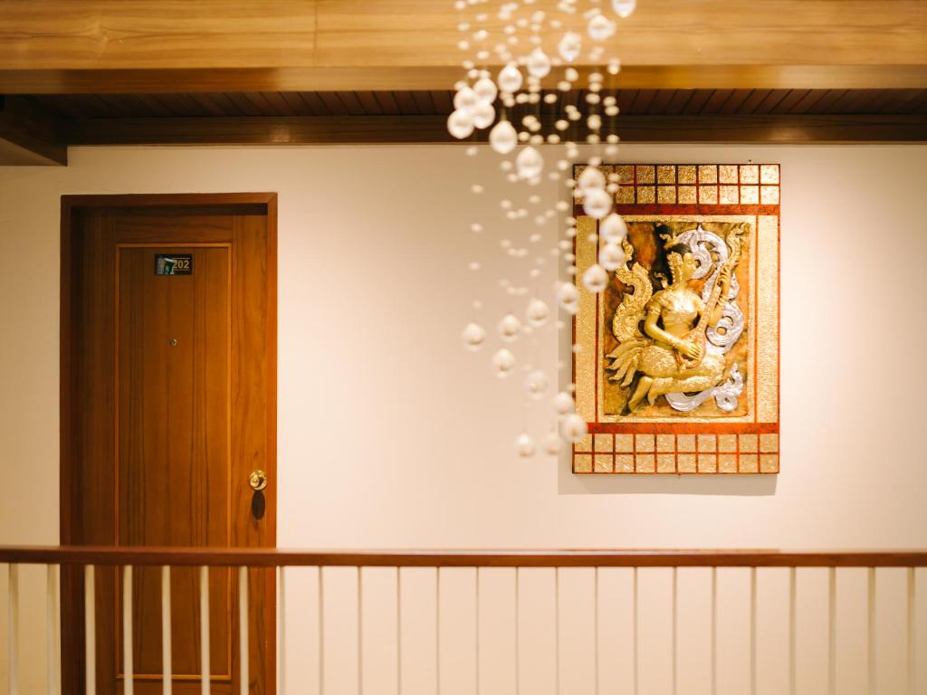 a chandelier with a picture of a deity on a wall at Rendezvous Classic House in Chiang Mai