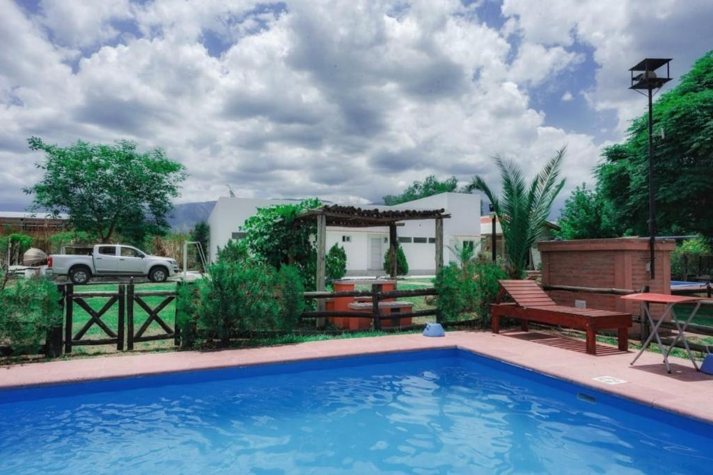 a swimming pool with a bench and a gazebo at Cabañas Villa del Sol in Salta