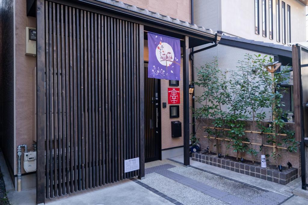 einen Eingang zu einem Gebäude mit einem Schild an der Tür in der Unterkunft 【Kyoto 幸】東寺まで１分、京都駅から15分！立地が便利な丸ごと貸し切る一軒家 in Kyoto