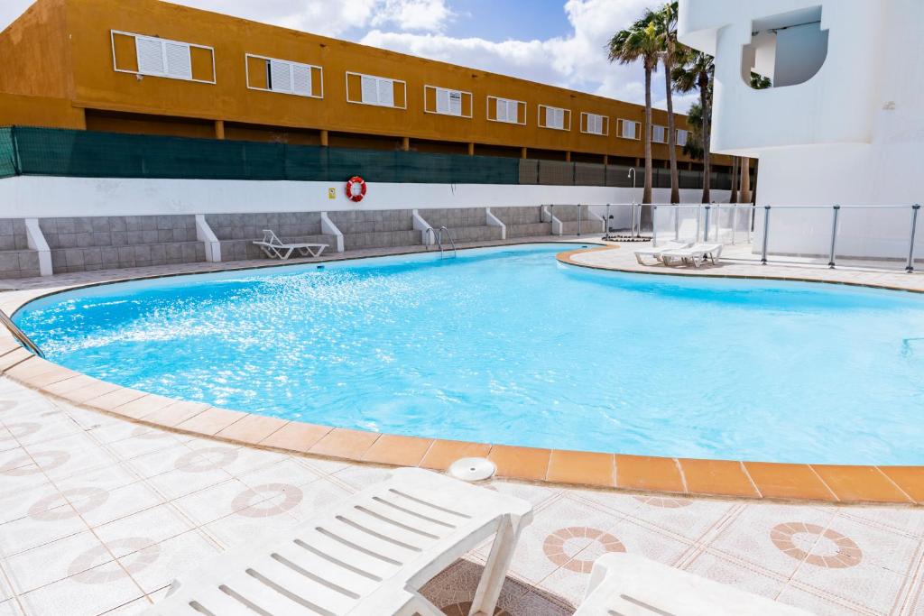 a large pool in a hotel with chairs and a building at Casa Tropical in Costa de Antigua