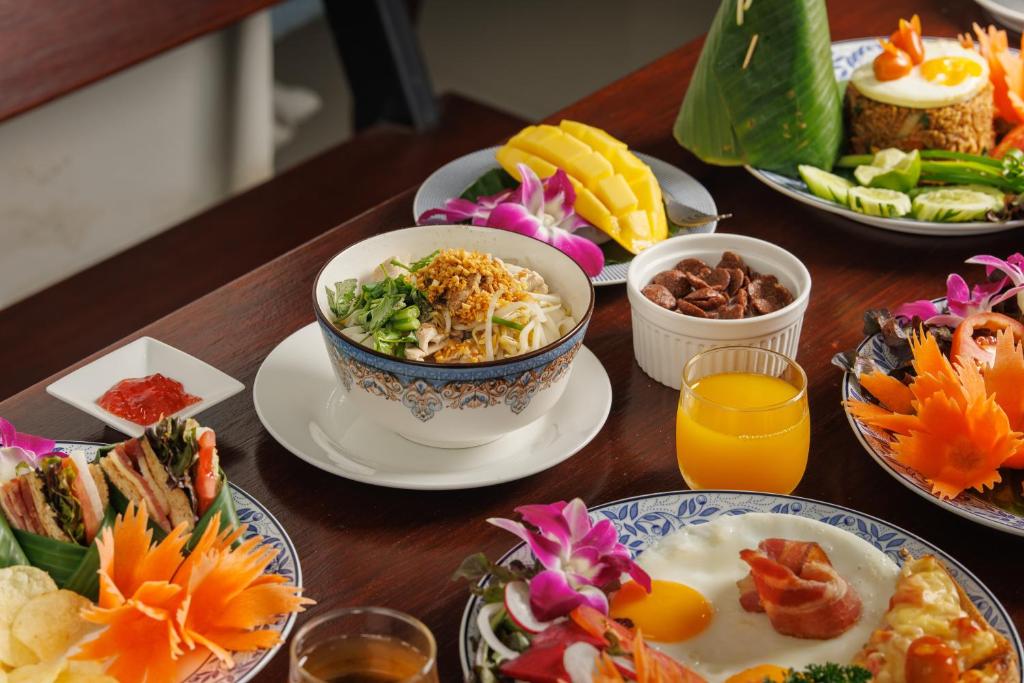 a wooden table with plates of food on it at Rendezvous Classic House in Chiang Mai