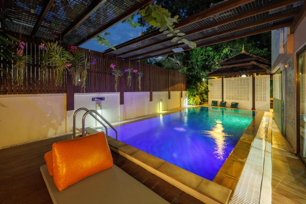 a swimming pool in the middle of a house at Rendezvous Classic House in Chiang Mai