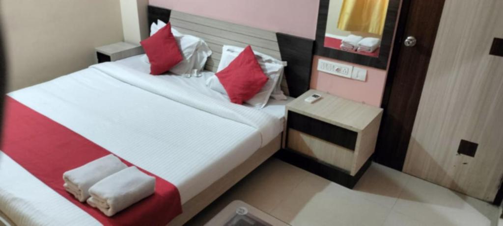 a bedroom with a bed with red and white pillows at Goroomgo Golden Beach Inn Puri Near Sea Beach in Puri