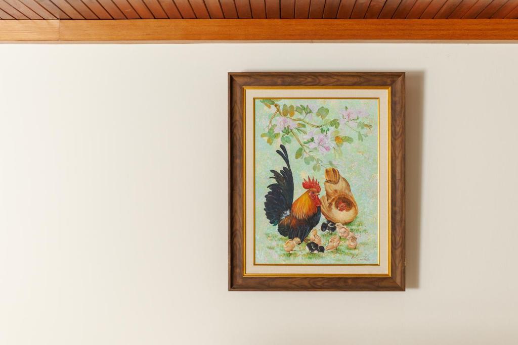 a framed picture of a chicken on a wall at Rendezvous Classic House in Chiang Mai