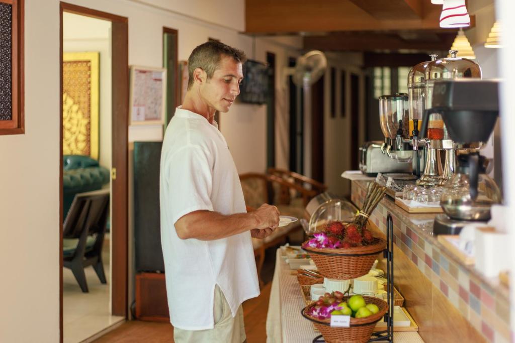 a man standing in a kitchen preparing food at Rendezvous Classic House in Chiang Mai