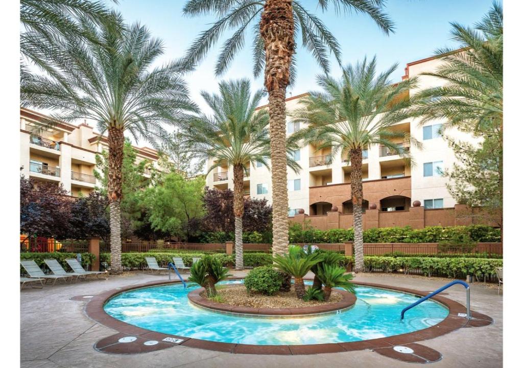 einen Innenhof mit Palmen und einem Pool in der Unterkunft Exclusive Condo Retreat Featuring a Lazy River - Special Offer Now! in Las Vegas