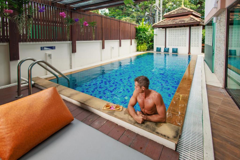 a man sitting in a swimming pool at Rendezvous Classic House in Chiang Mai