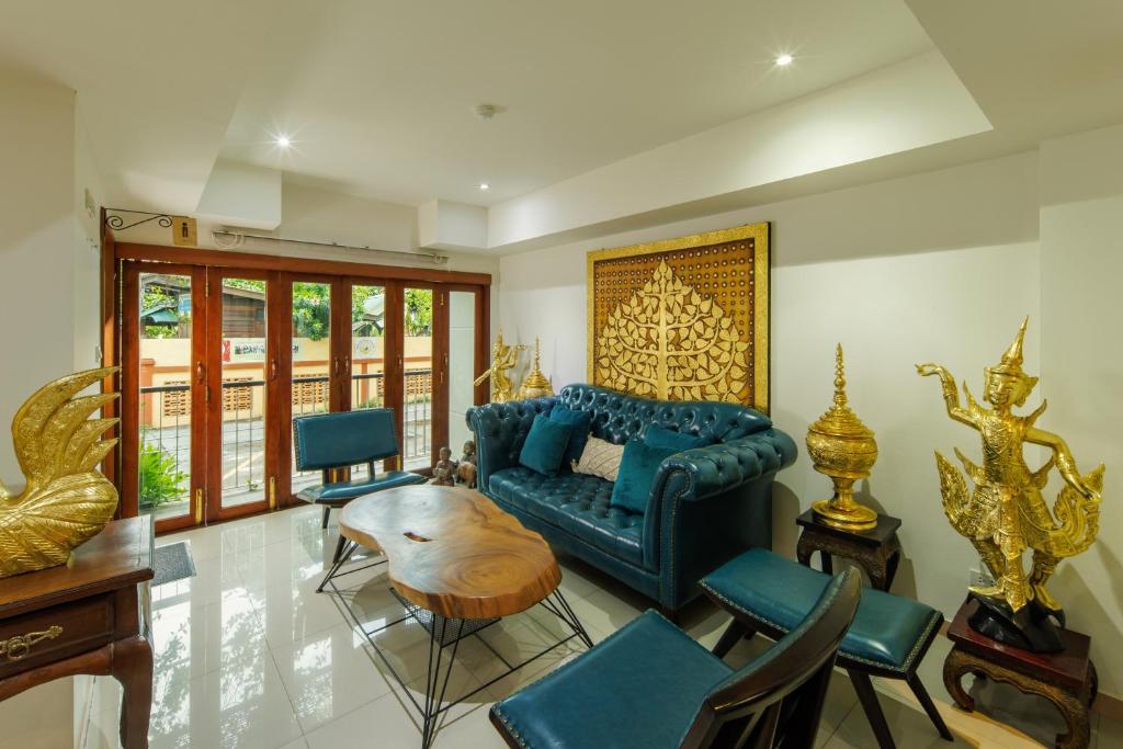 a living room with a blue couch and chairs at Rendezvous Classic House in Chiang Mai