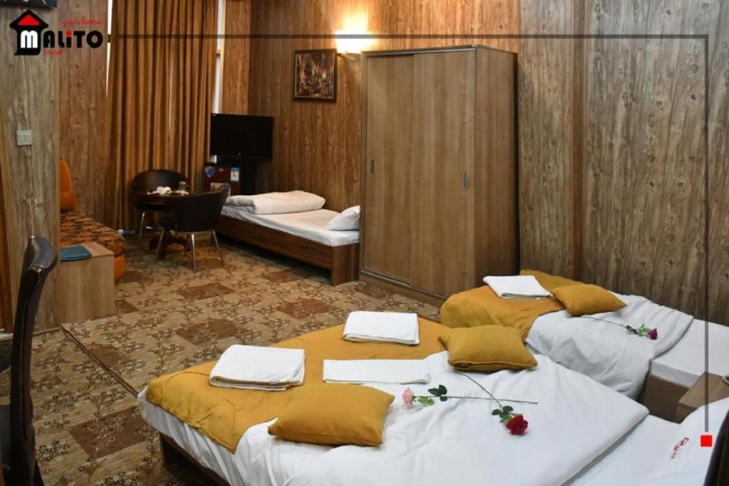 a hotel room with two beds in a room at Malito in Erbil