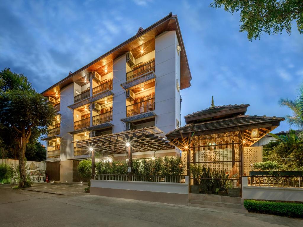 an exterior view of a building with lights at Rendezvous Classic House in Chiang Mai
