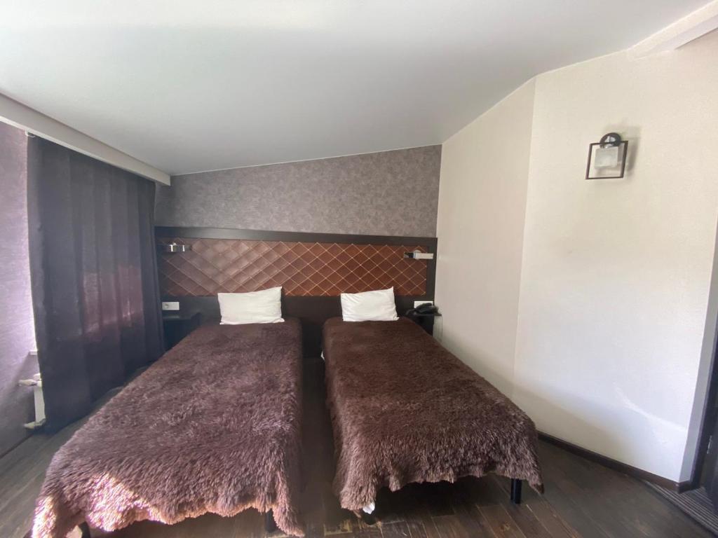 - une chambre avec 2 lits et des couvertures brunes dans l'établissement Afina Aparthotel, à Odessa