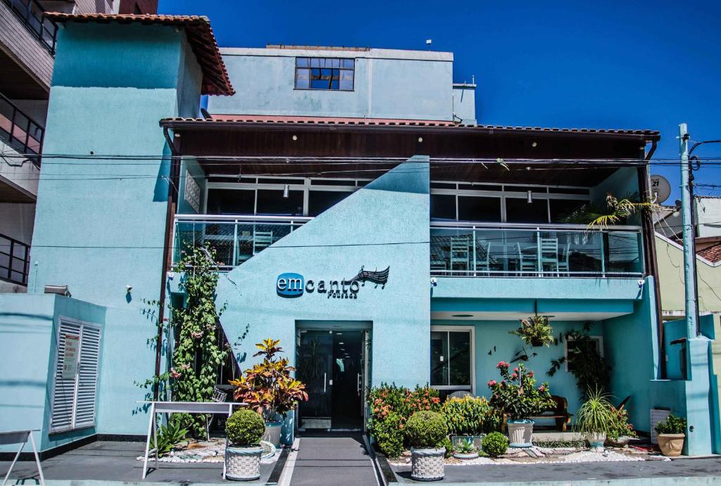 a blue building with a sign on it at Pousada Emcanto in Vila Muriqui