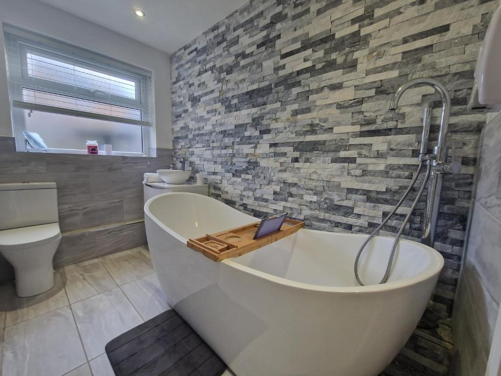 a bathroom with a bath tub and a toilet at 3 bedroom modern house. Merthyr Tydfil near bike park wales and Brecon Beacons National park in Dowlais