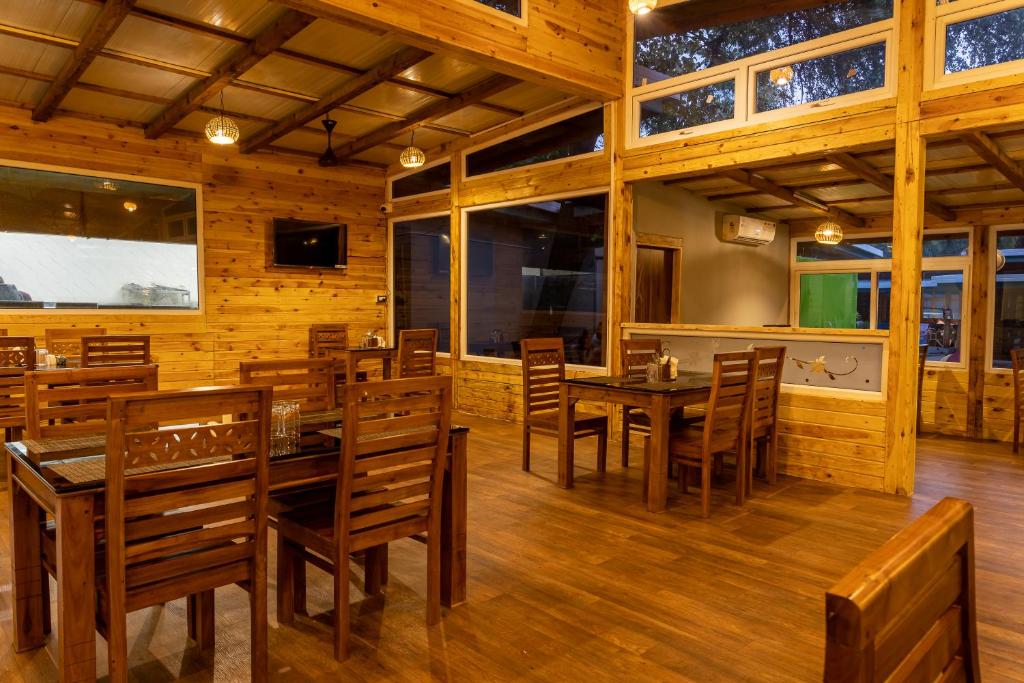 a dining room with wooden tables and chairs at Oxygen Palolem in Palolem