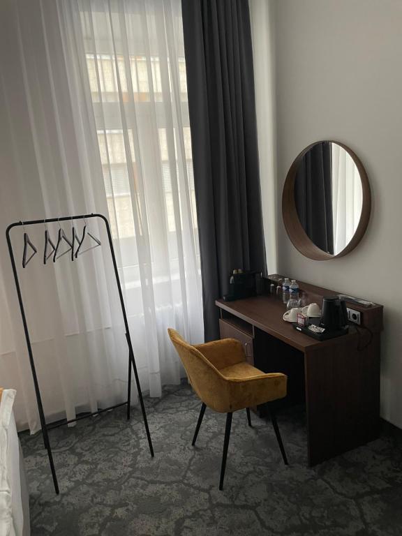 um quarto com uma secretária, um espelho e uma cadeira em Hotel Royal em Praga
