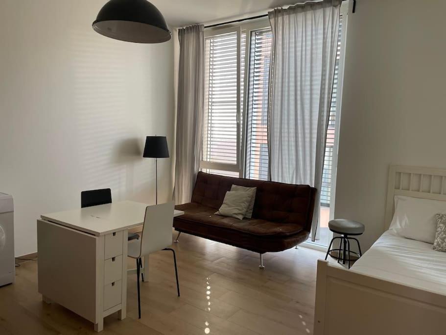 een woonkamer met een bank, een bureau en een bed bij Mont-sur-Lausanne: Studio très cosy ! in Le Mont-sur-Lausanne