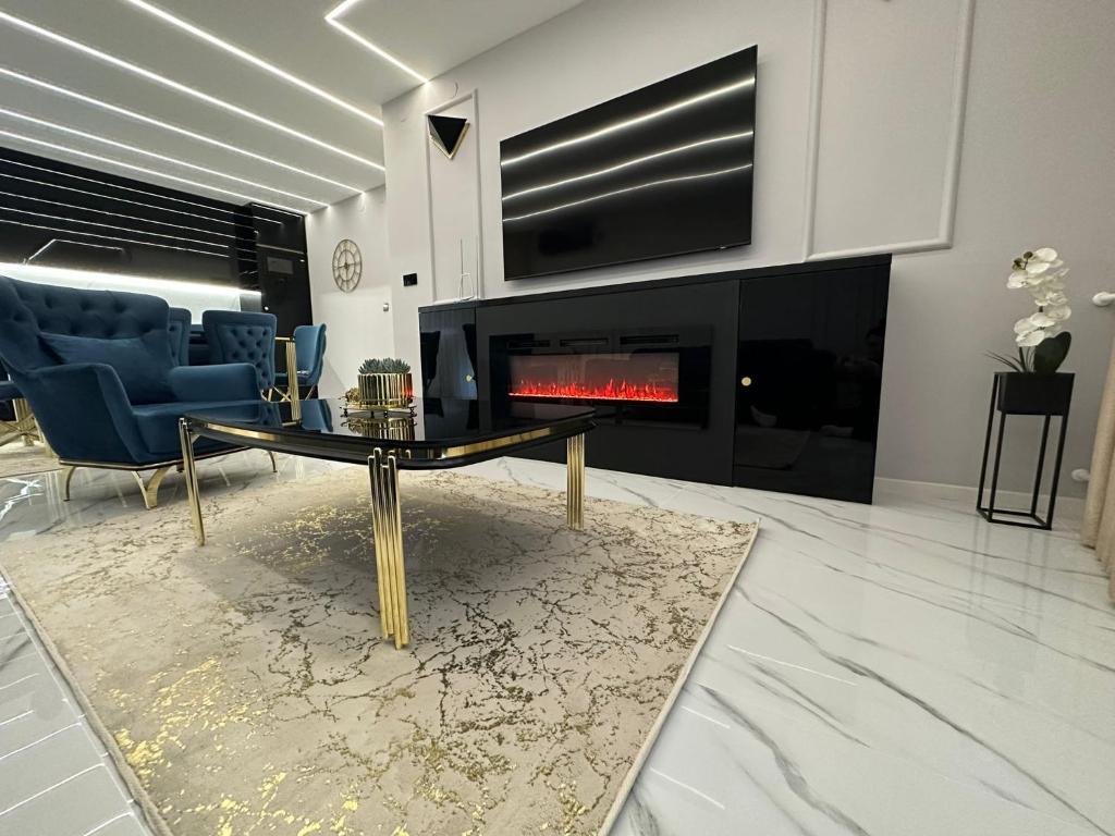 a living room with a table and a fireplace at APARTMANI JERKOVIĆ - DUNAV 1 - Premium in Vukovar