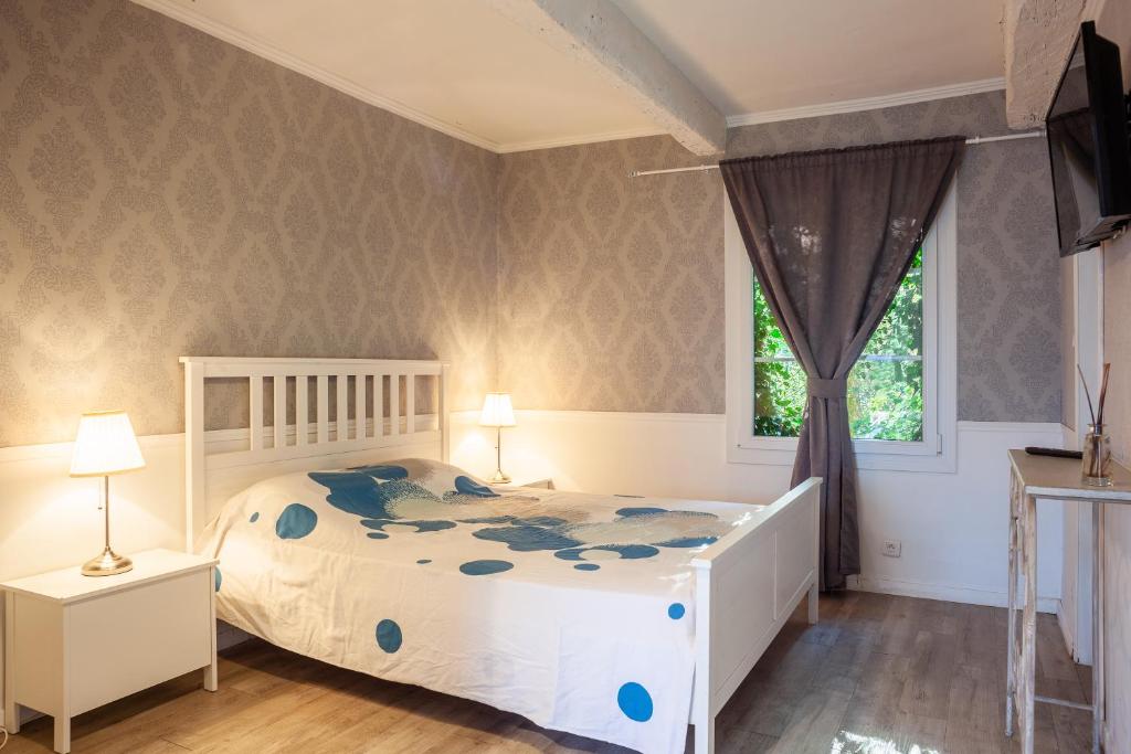 1 dormitorio con cama blanca y ventana en Studio Romantique à Saint Zacharie, en Saint-Zacharie