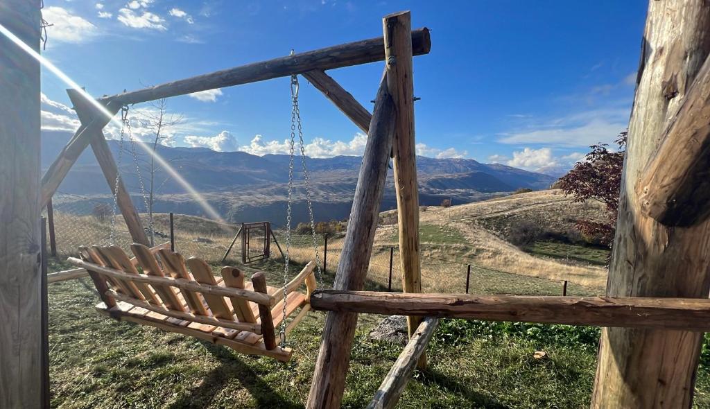 a swing in a field with mountains in the background at Guest House Highland in Pluzine