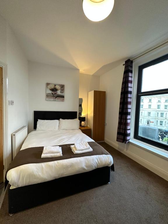 Un dormitorio con una cama grande y una ventana en The Carlton's Holiday Suites, en Bridlington
