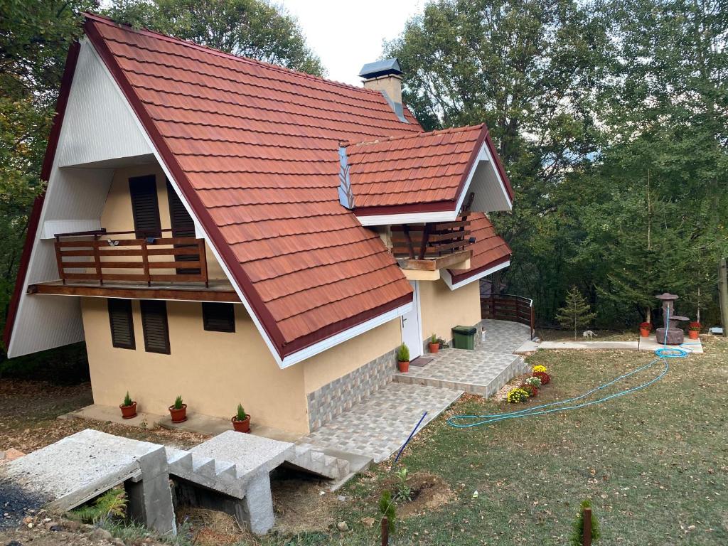 a house with a red roof and a yard at Mountain Vila in Ponikva in Kočani