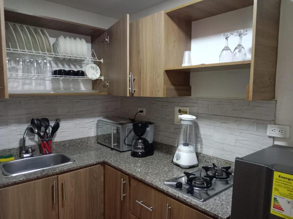 eine Küche mit einer Spüle und einem Herd Top-Backofen in der Unterkunft House Hotel Sweet Home 2 apartments in Medellín