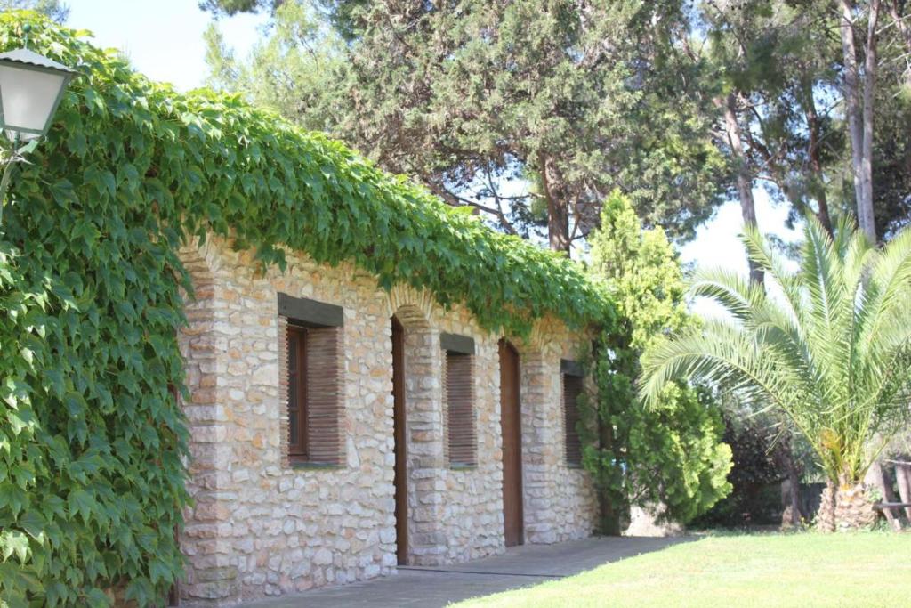 un edificio de ladrillo con hiedra a un lado en Cal Marques, en Santa Oliva