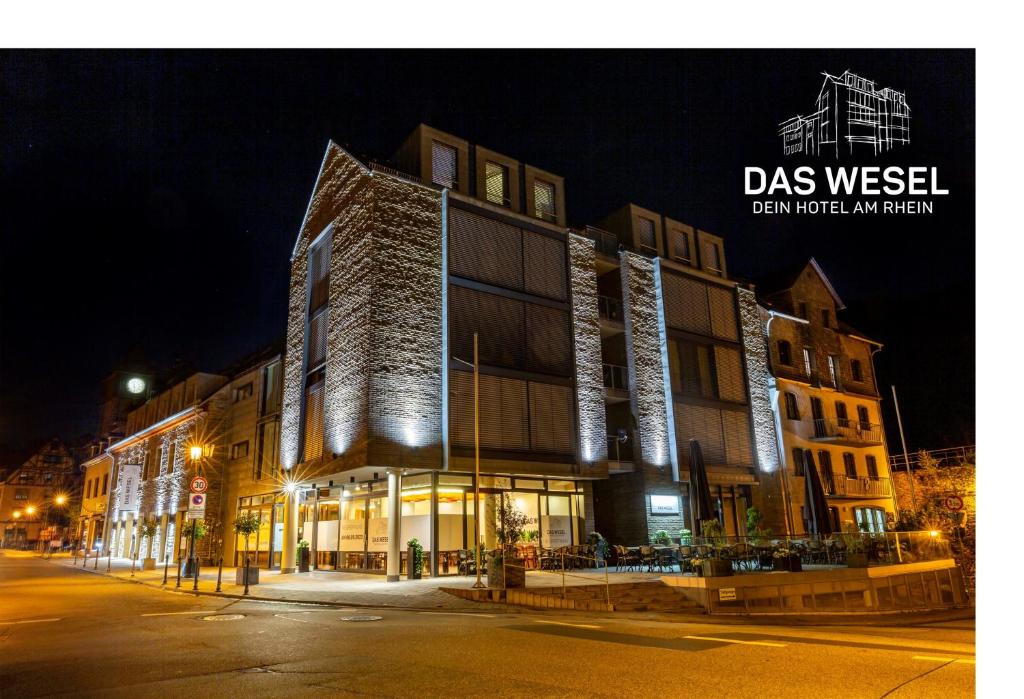 un bâtiment éclairé dans une rue la nuit dans l'établissement DAS WESEL - DEIN HOTEL AM RHEIN, à Oberwesel