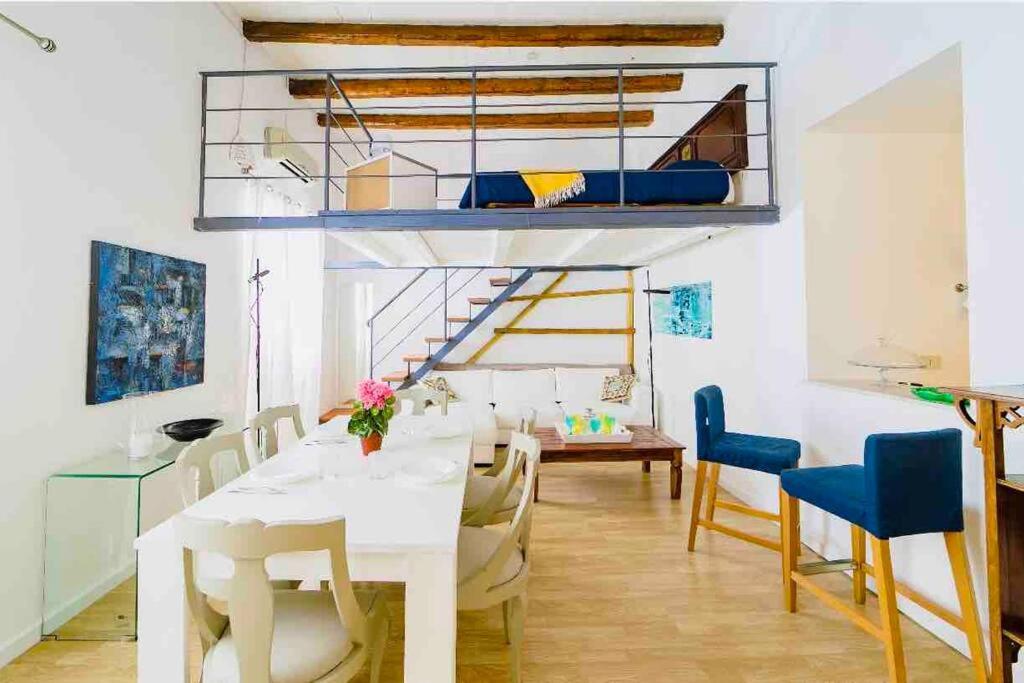 a room with a dining table and a loft bed at Archimede Suite Apartment - Morici Street in Palermo