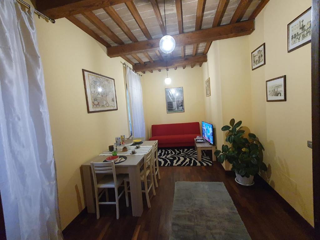 a living room with a table and a red couch at la Suite del Suffragio in Viterbo