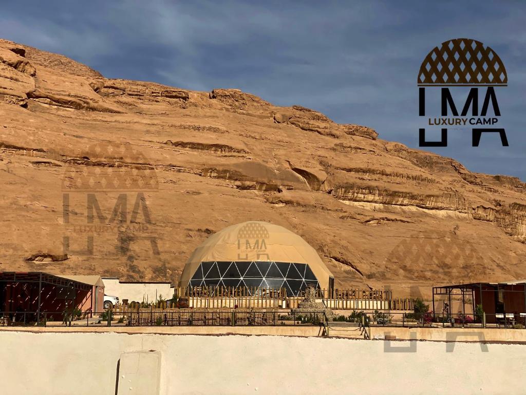 un bâtiment en face d'une montagne rocheuse dans l'établissement Lma Luxury Camp, à Wadi Rum
