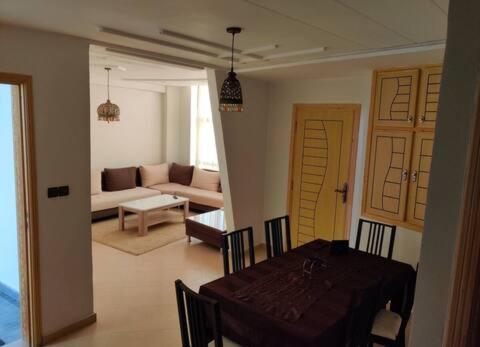 ein Esszimmer mit einem Tisch und ein Wohnzimmer in der Unterkunft Appartement Wynwood 2 in Oujda