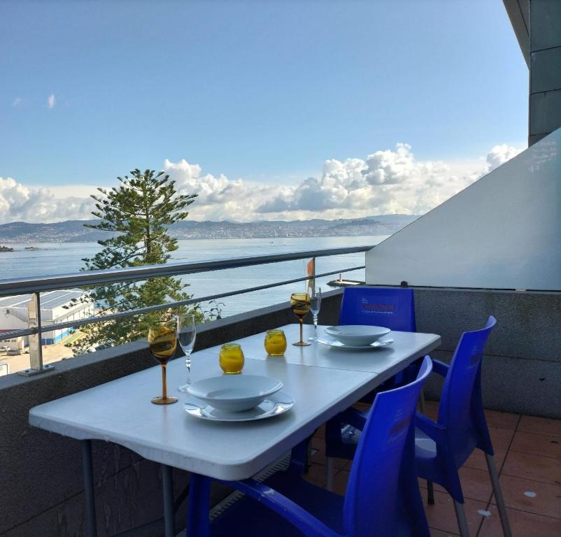 una mesa con 2 copas de vino en el balcón en Apartamento Punta Balea, en Cangas de Morrazo