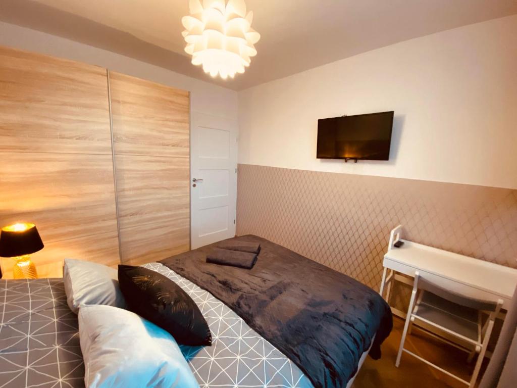 sypialnia z łóżkiem, biurkiem i telewizorem w obiekcie ClickTheFlat Miła Center Apart Rooms w Warszawie