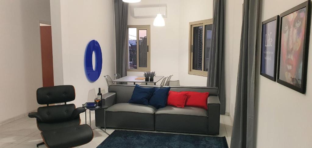 ein Wohnzimmer mit einem Sofa und einem Stuhl in der Unterkunft BLUE LUXURY APARTMENT (BREAKBOOKING CY-SERVICES LTD) in Limassol