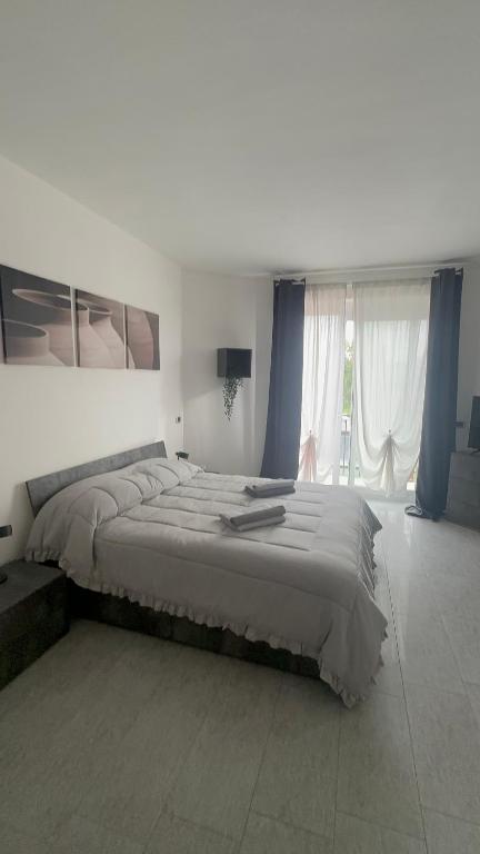 a large bed in a bedroom with blue curtains at ] DOMA [ in Inveruno