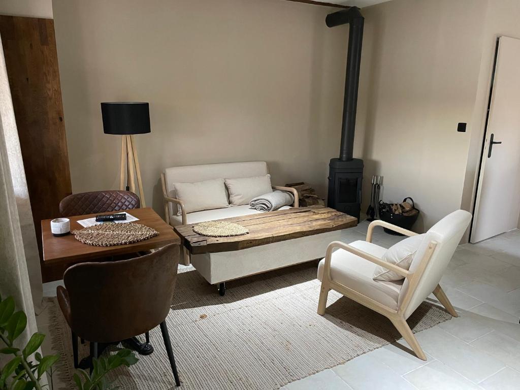 een woonkamer met een bed en een tafel en stoelen bij Maison Les Roches Cadre unique in Rochefort-sur-Nenon