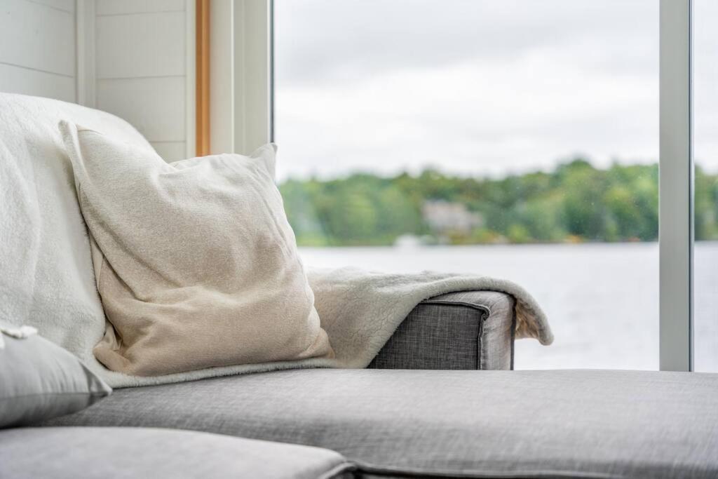 un divano con coperta, seduto di fronte a una finestra di Allure Muskoka Houseboat a Huntsville